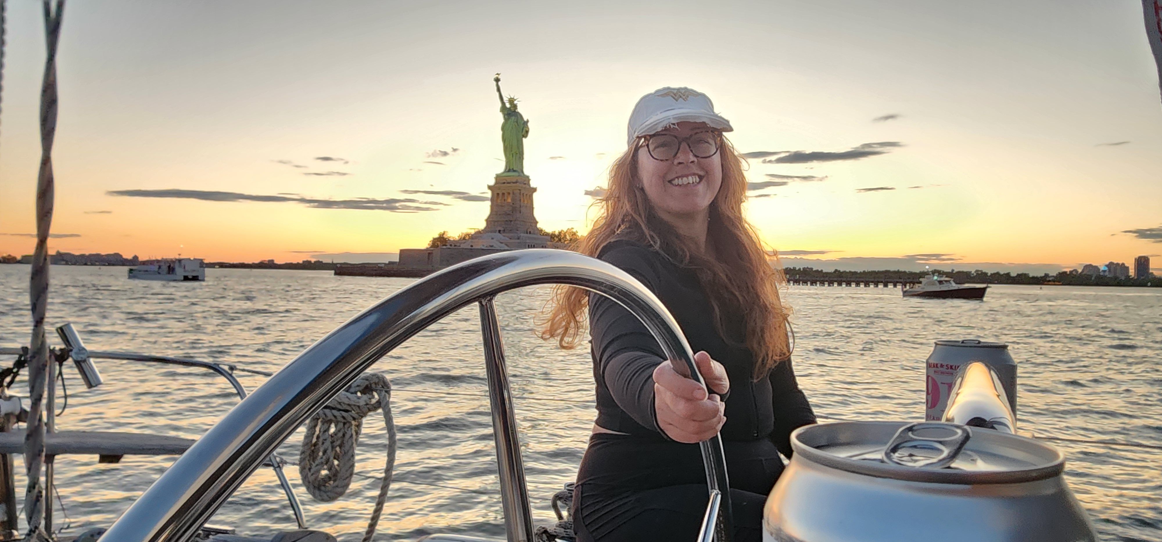 At the helm with the Statue of Liberty at sunset